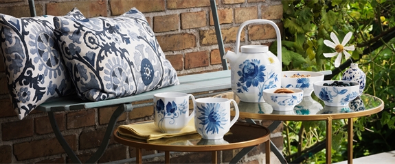 Garden table around tea time set with blomst teapot and mugs plus a blomst bowl with sweets