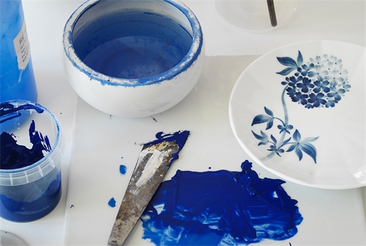 a blomst plate being painted with the iconic blue colour