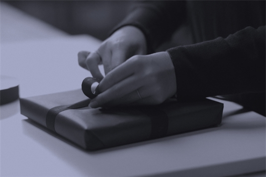 Et Royal copenhagen produkt bliver pakket ind i det ikoniske blå gavepapir